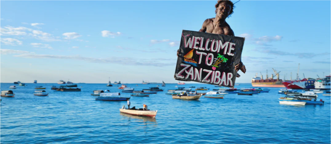 Welcome to Zanzibar sign over a harbour scene.