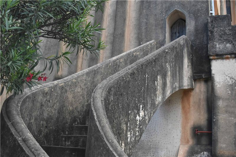 Curved exterior staircase on an old stone building.