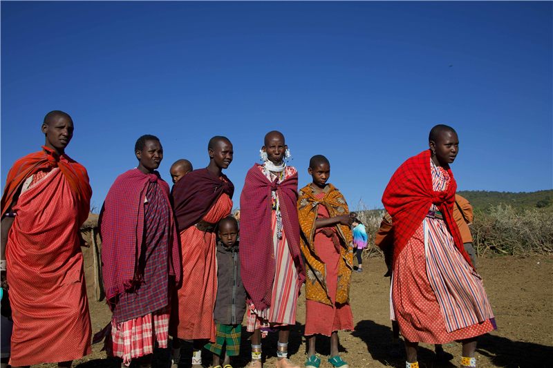 People in red traditional clothing on an open plain.